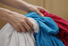 hands carefully separating white clothes from colored ones before washing create in horizontal format do not write text on image