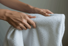 hands carefully folding a freshly laundered towel with a focus on its soft texture create in horizontal format do not write text on image