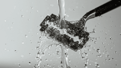 a sharp razor blade being rinsed under hot water to remove hair and debris create in horizontal format do not write text on image
