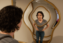 A person looking at their reflection in a distorted mirror