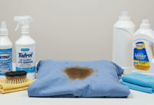 various cleaning supplies and a stained garment on a clean surface ready for stain removal create in horizontal format do not write text on image