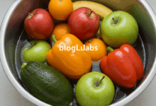 a variety of colorful fruits and vegetables neatly arranged in a clean bowl ready for washing with natural cleaning agents like baking soda and vinegar this image should have a bloglabs watermark in the center in a translucent style create in horizontal format do not write text on image