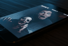 a phone screen showing a viral jumpscare video with a shocked face reflection