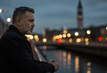 A man standing alone on a bridge looking reflective with a blurry city background representing introspection and personal struggles leading to disinterest in a romantic relationship