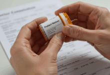 A person's hands carefully handling a prescription medication with a doctor's consultation form visible in the background emphasizing safe and informed drug use
