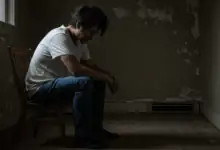 a person sitting alone in a room looking distressed